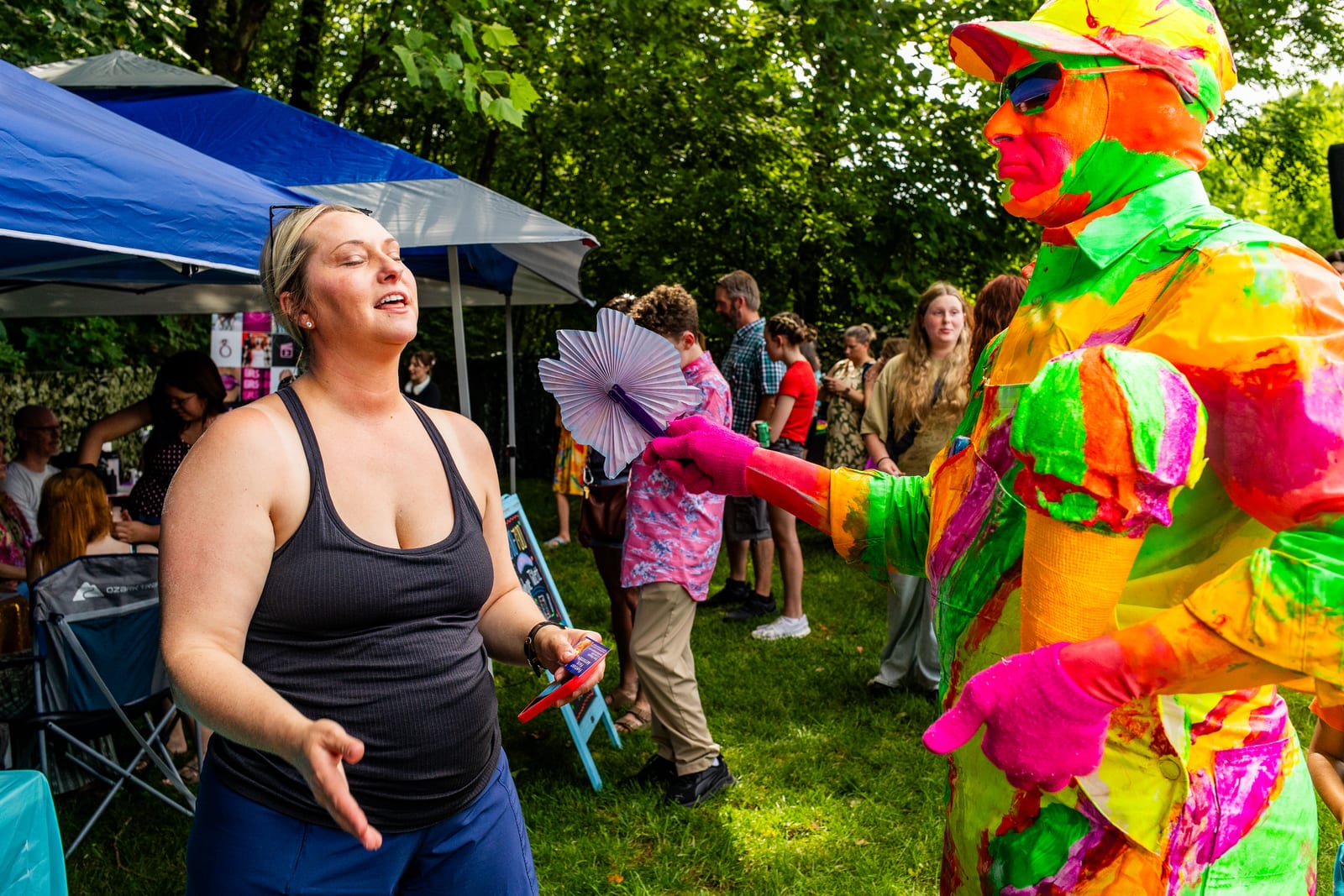 Guest laughing as a performer in a vivid neon suit entertains the crowd