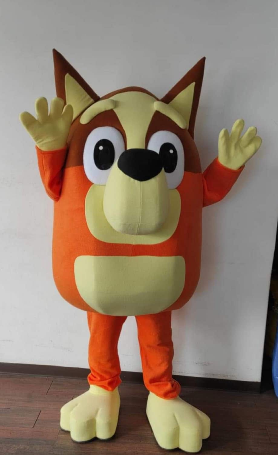 Blue cartoon-dog mascot performer standing with arms raised in greeting