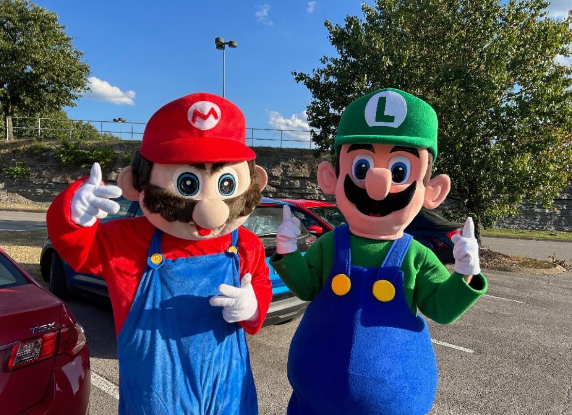 Red-capped and green-capped video-game plumber mascots posing outdoors