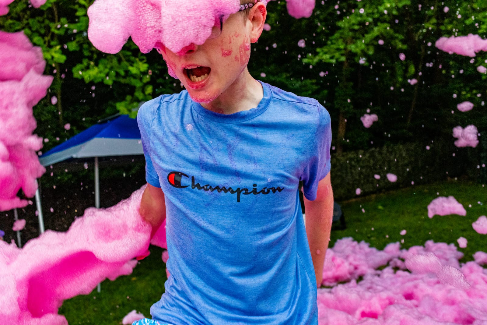 Young guest shouting with delight in billowing pink party foam