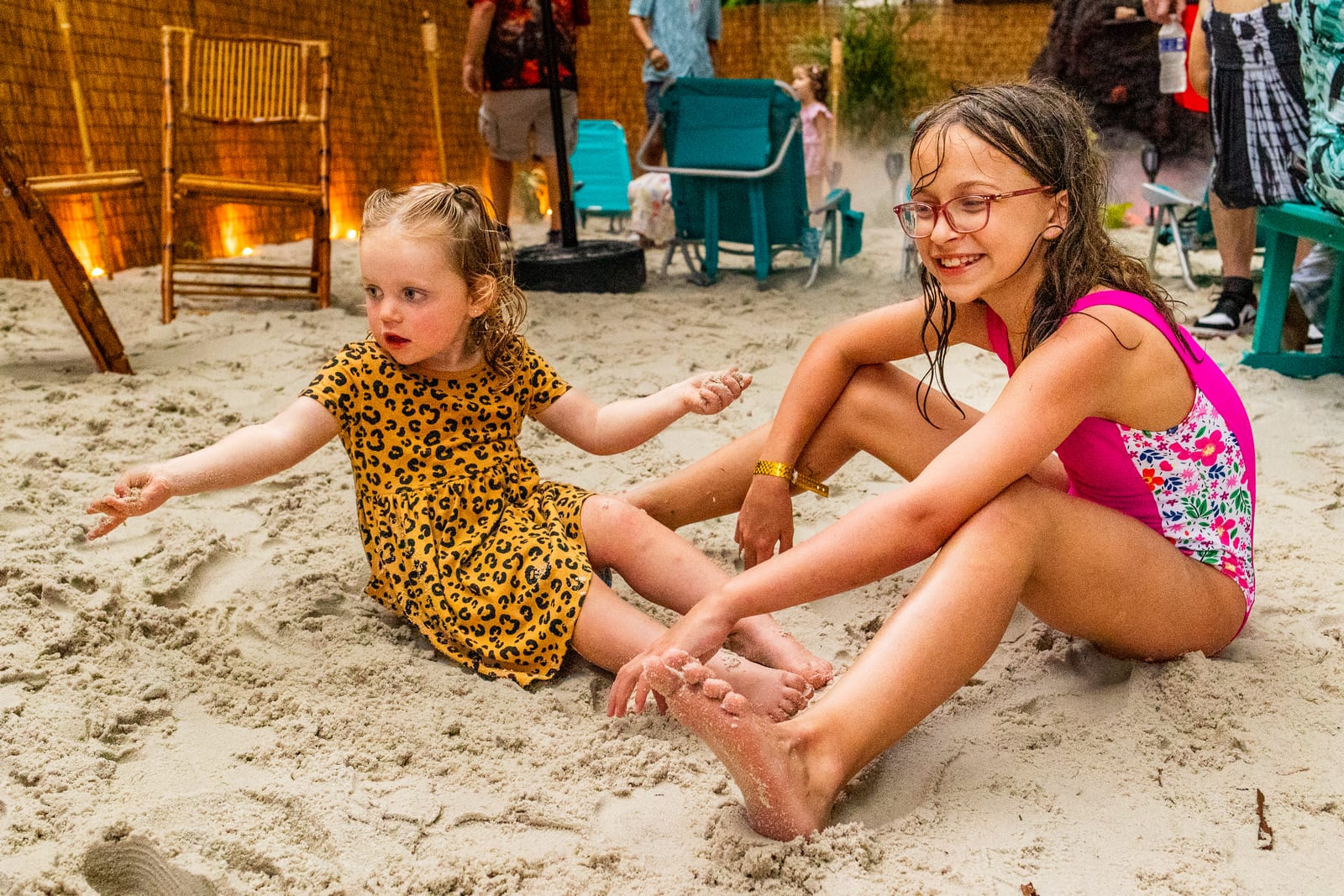 Two children playing in the sand at an outdoor beach-style play area