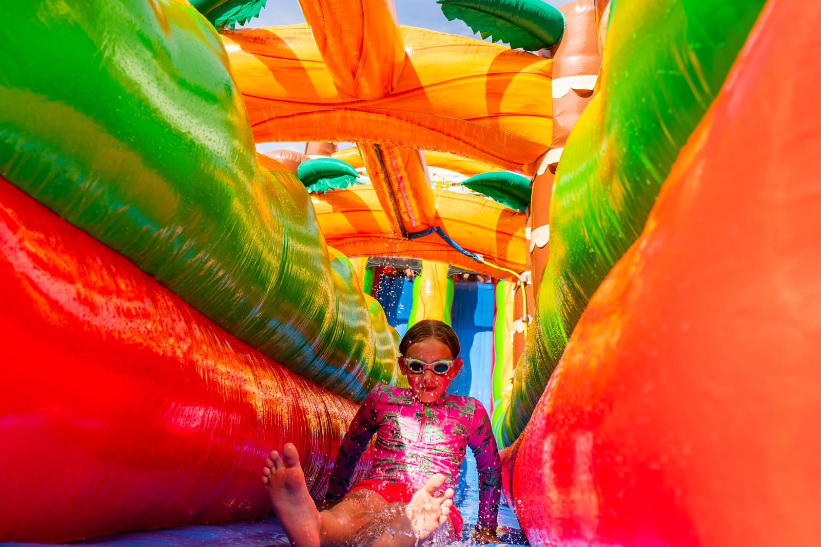 Child sitting inside a brightly colored inflatable bounce house