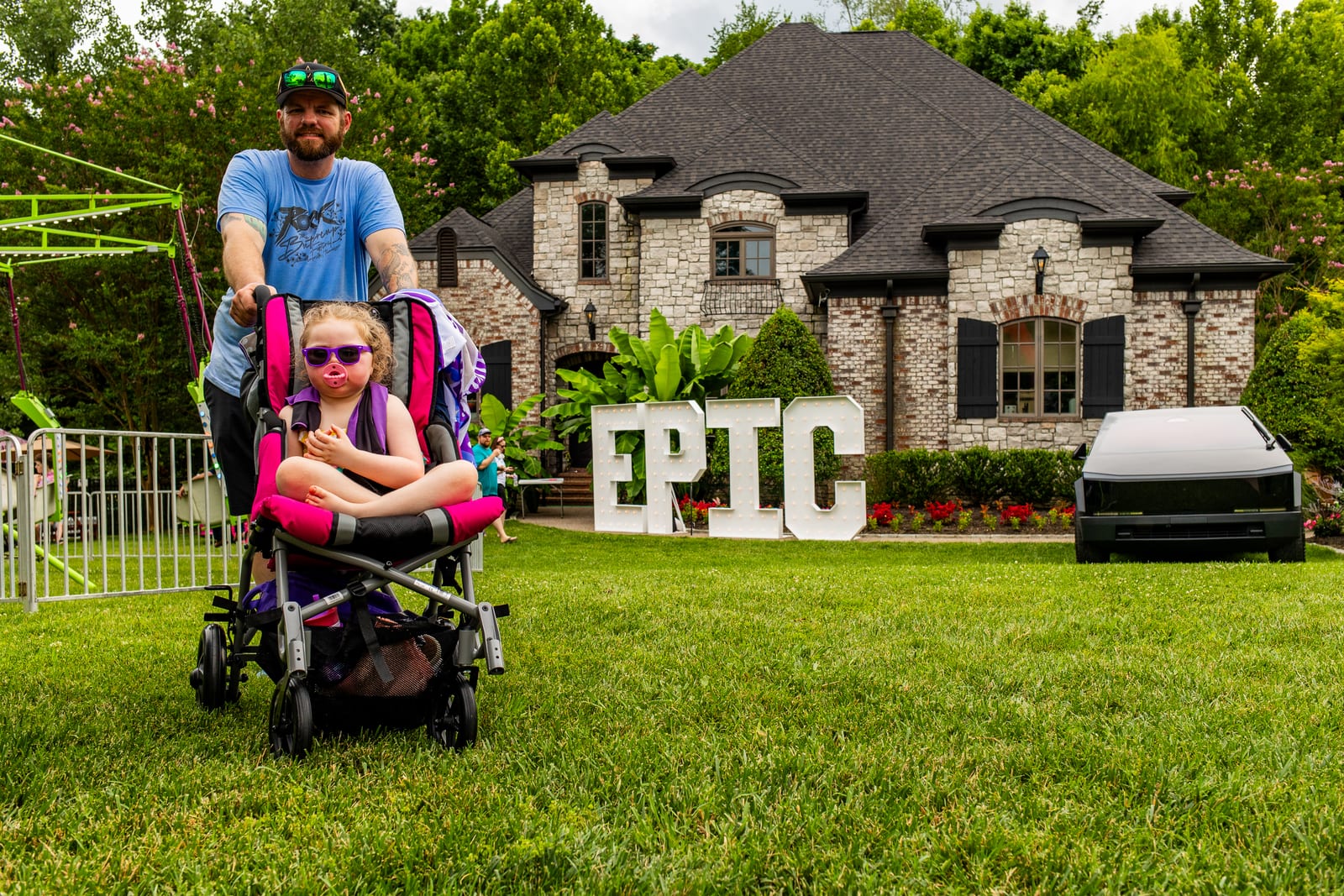 Large white EPIC marquee letters standing on a lawn in front of a stone house