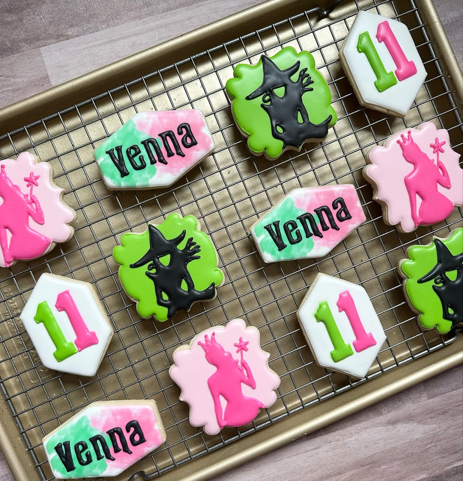 Iced sugar cookies decorated with names, the number eleven and green witch silhouettes