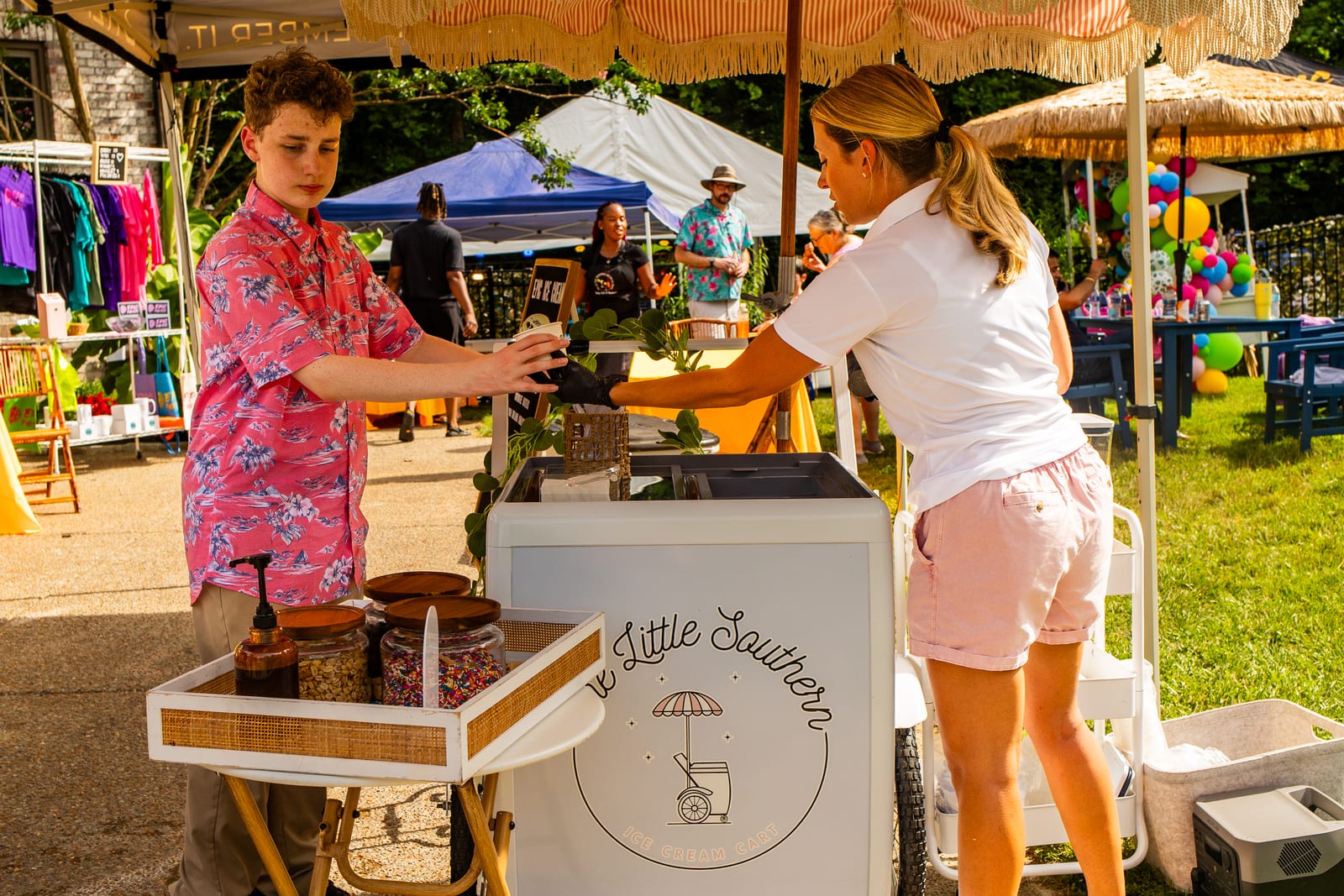 Attendant serving a guest from a white mobile coffee and dessert cart