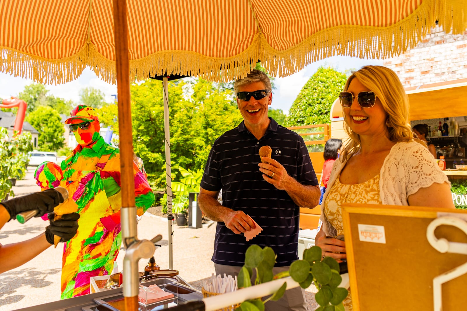 Guests collecting ice cream at a fringed cart served by a costumed attendant