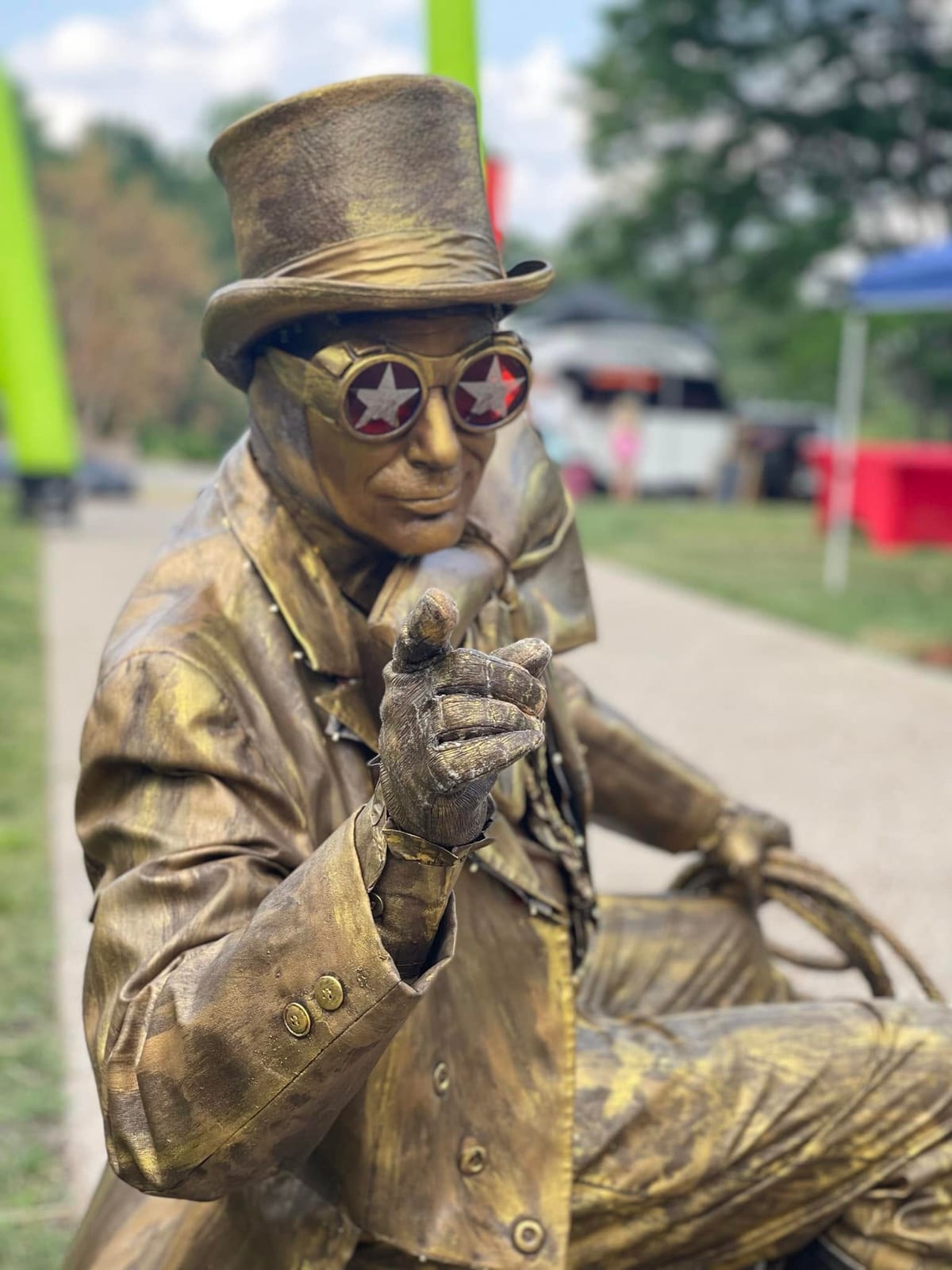 Bronze-painted living-statue performer in a top hat posing at close range