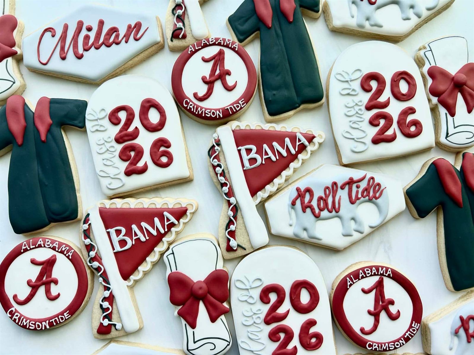 Crimson and white Alabama grad cookies with caps, 2026 and Roll Tide details on a dessert table
