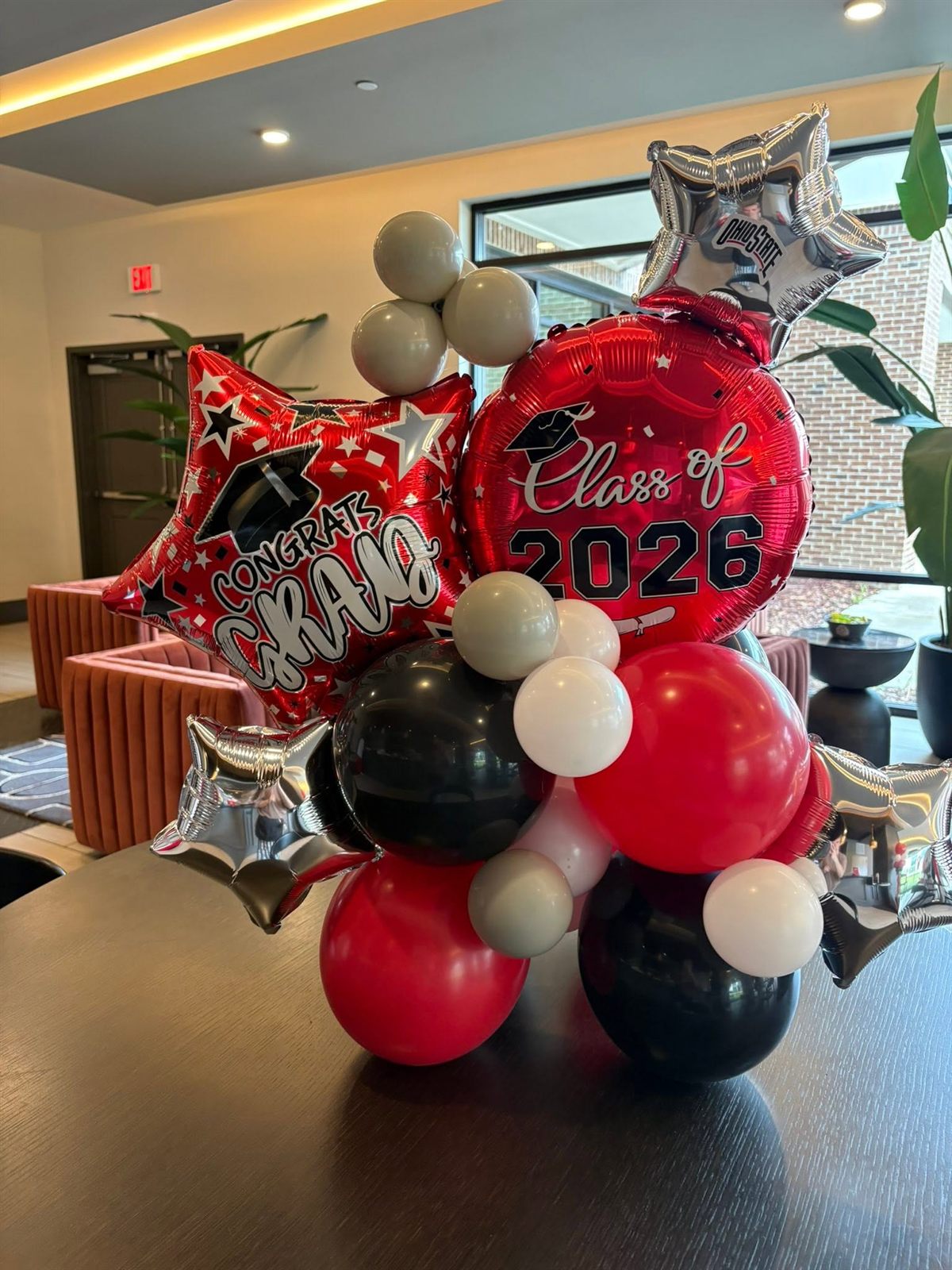 Red, black and silver grad balloon centerpiece with a Congrats Grad star and Class of 2026 foil