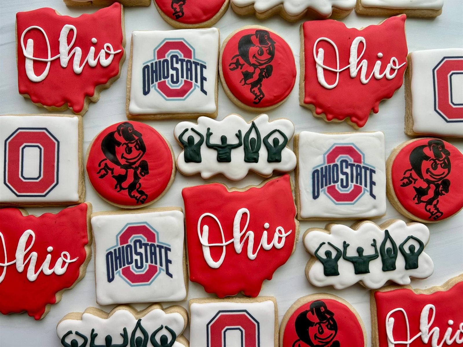 Ohio State grad cookies with Ohio script, the Buckeyes O logo, Brutus mascot and O-H-I-O arms