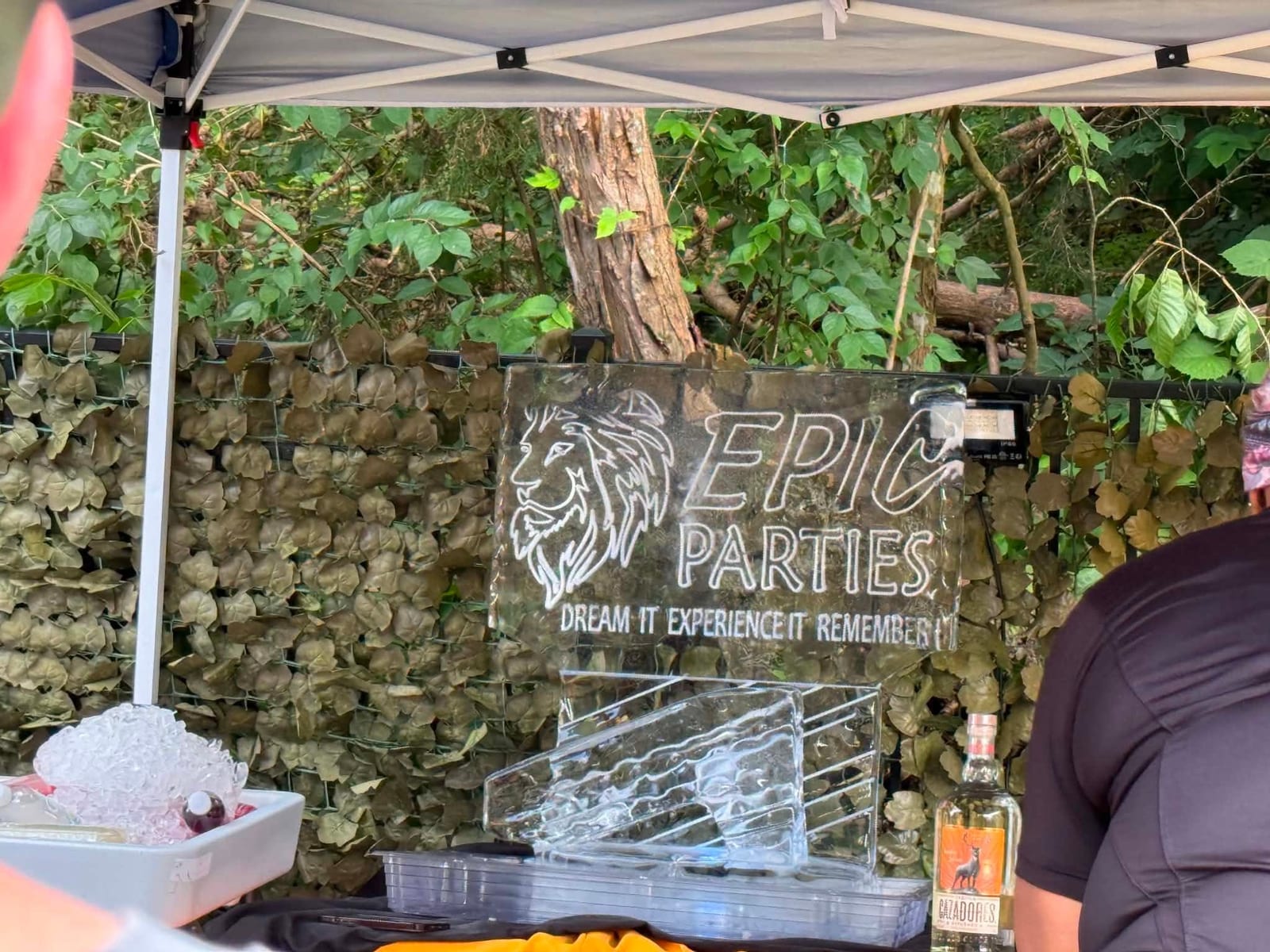 Carved ice luge etched with the EPIC Parties lion logo set up at an outdoor bar