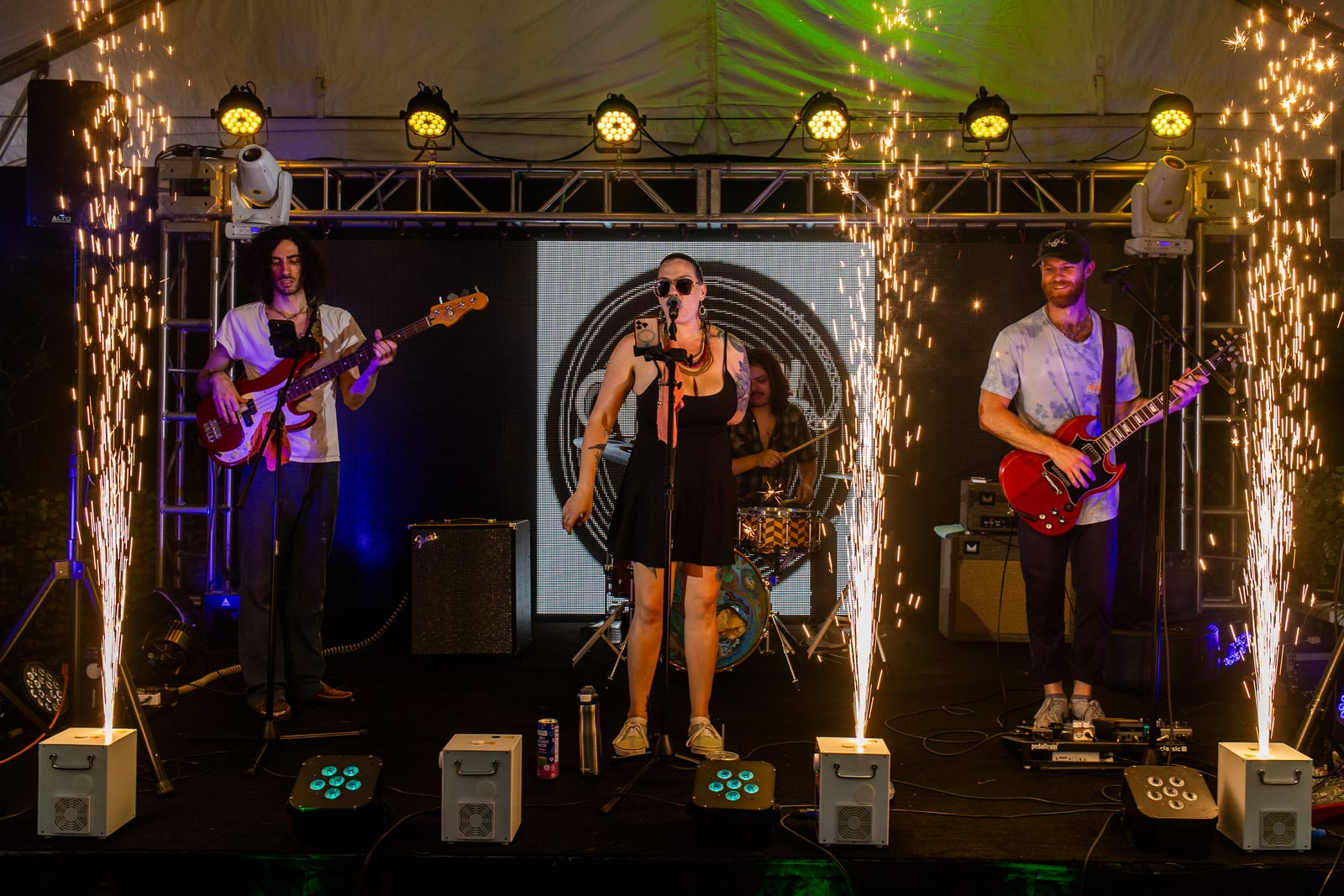 Live band performing as cold spark fountains fire from the front of the stage