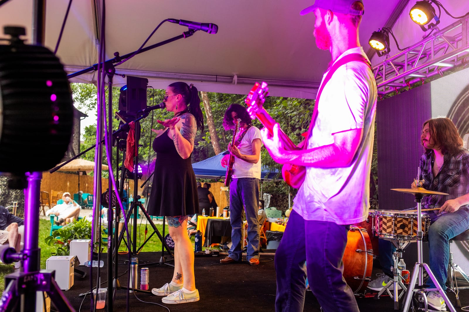 Band performing under a marquee washed in purple stage lighting