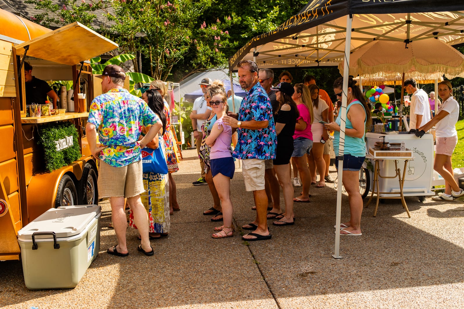 Guests queuing at a mobile bar trailer at an outdoor party