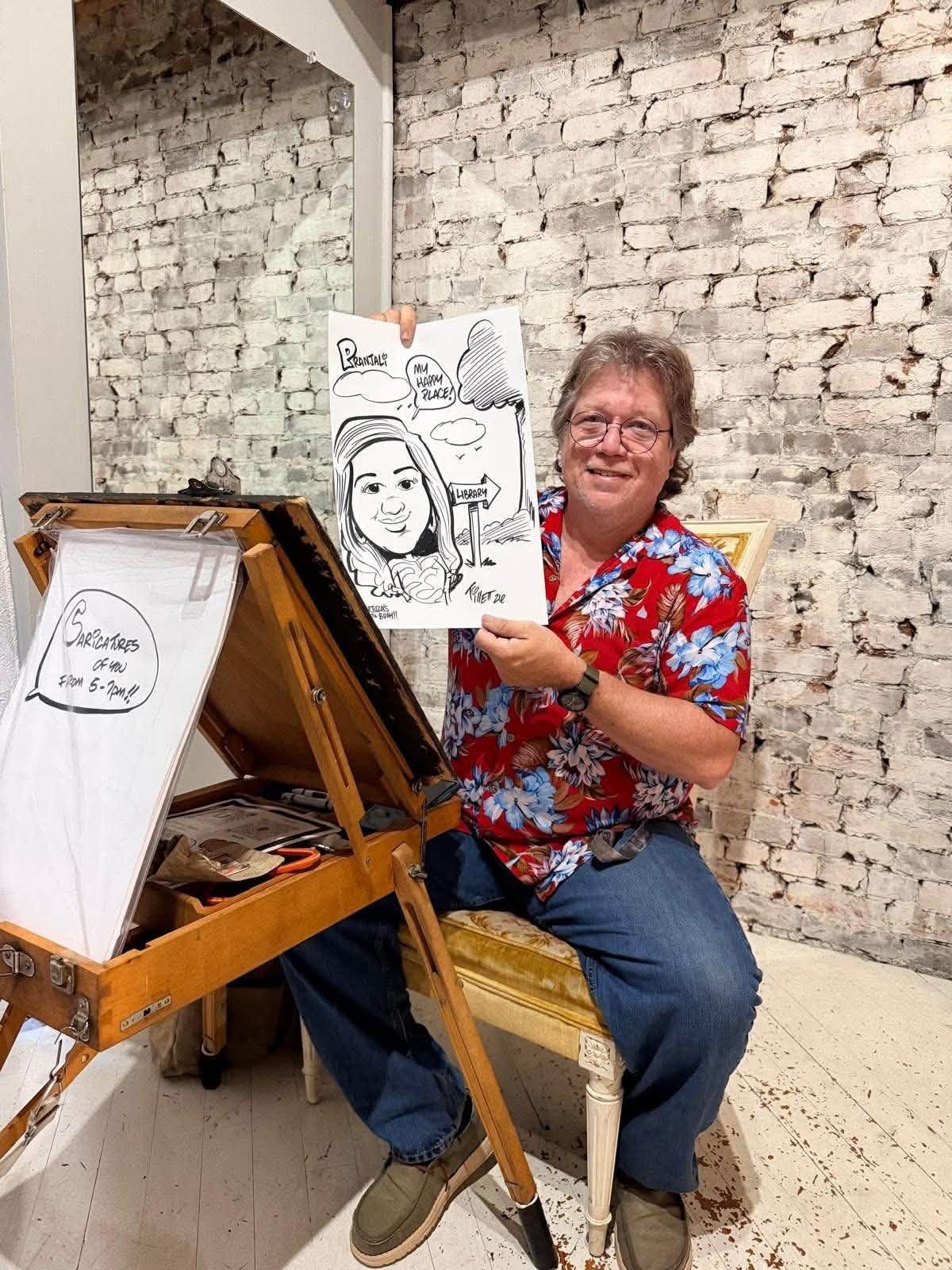 A printed art show sign on a white easel beside an abstract painting on a gallery wall